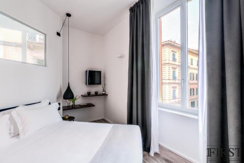 a bedroom with a white bed and a large window at La Spezia by The First - Luxury Rooms & Suites in La Spezia