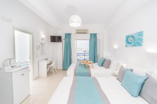 a white living room with a white couch and blue pillows at Kafieris View in Firostefani