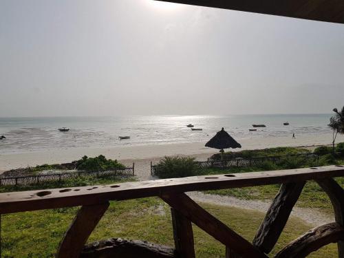 a view of a beach with an umbrella and the ocean at White Sands in Paje