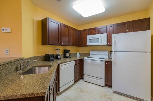a kitchen with white appliances and wooden cabinets at Vacation Village in the Berkshires in Hancock