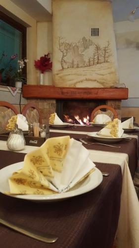 a table with plates and napkins and a fireplace at gostišče uh- planica in Rateče