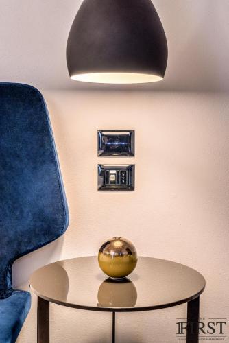 a table with a bowl on it under a lamp at La Spezia by The First - Luxury Rooms & Suites in La Spezia