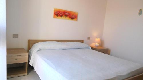 サンタ・テレーザ・ガッルーラにあるCasa Vacanze La Bandera 2のベッドルーム1室(ベッド1台付)が備わります。壁には絵画が飾られています。