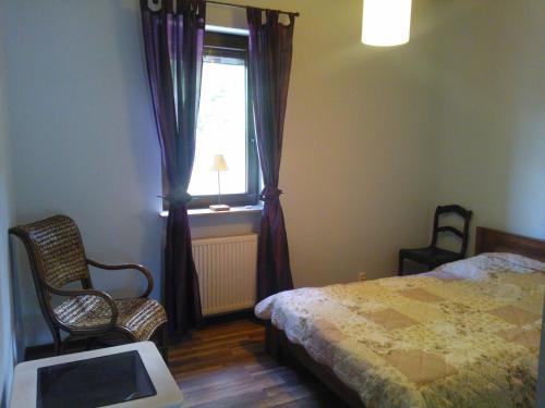 una camera con letto, finestra e sedia di Dom w Dominikowie a Dominikowo