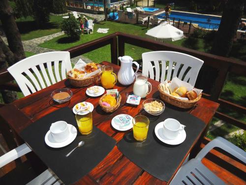 een houten tafel met ontbijtproducten en drankjes erop bij La Posta de Cariló in Carilo