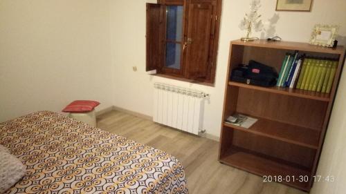 a bedroom with a bed and a book shelf at Casolare Toscano in Lorenzana