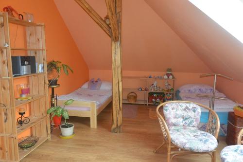 a attic room with two beds and a chair at Rodinné ubytování - Family accommodation in Kobylice