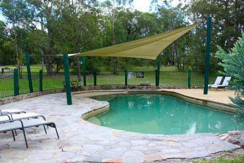 a swimming pool with a tan umbrella over it at Valley View Luxury Retreat in Vacy