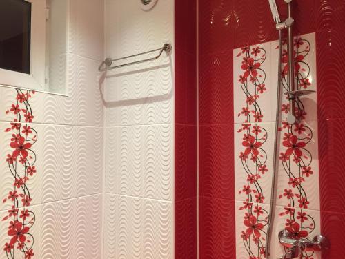 prysznic z czerwono-białą zasłoną prysznicową w obiekcie Elenite Guesthouse w mieście Goce Dełczew