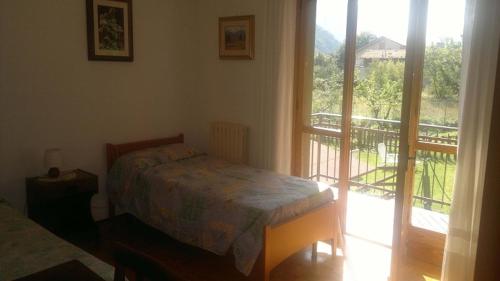 a bedroom with a bed and a balcony at Champdepraz Casa Vacanze in Champdepraz