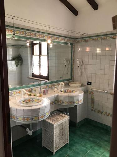 a bathroom with two sinks and a large mirror at B&B Il Martin Pescatore in Bagnolo San Vito