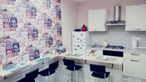 a kitchen with a counter with chairs and a refrigerator at La Cabala b&b in Naples