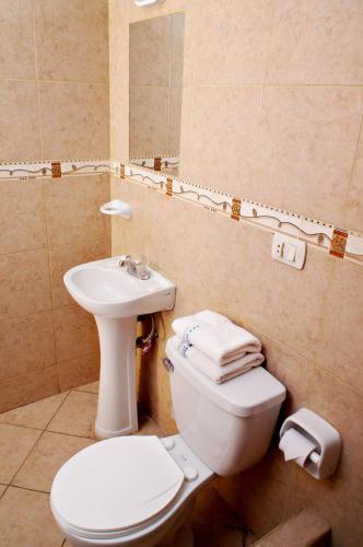 a bathroom with a toilet and a sink at Hotel Olaya in Lima