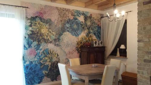 comedor con mesa y papel pintado con motivos florales en Dom w Dominikowie en Dominikowo