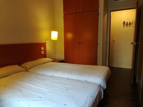 two twin beds in a room with a door open at Multipropiedad Baqueira 1500 in Baqueira-Beret