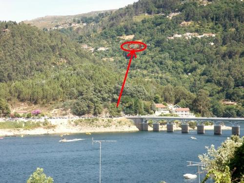 a red kite flying over a river with a bridge at Casa de Casarelhos - "Gerês" - Estúdio piso 0 - Apartamento Piso 1 in Geres