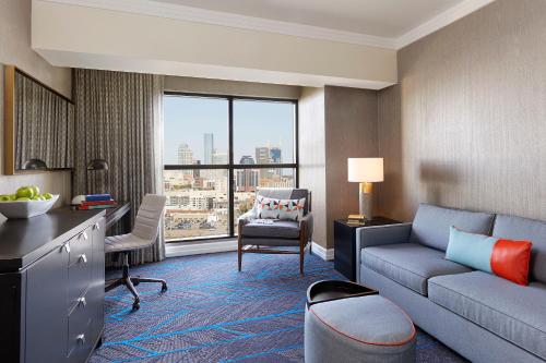 a living room with a couch and a desk in a room at Hutton Hotel in Nashville