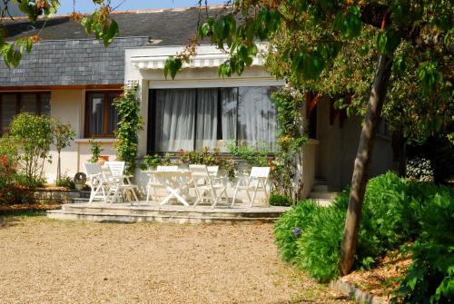 a group of chairs sitting on a patio in front of a house at Domaine du Parc in Montsoreau