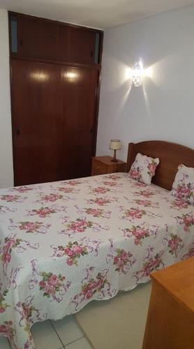 1 Schlafzimmer mit einem Bett mit Blumenbettdecke in der Unterkunft casa dos avós in Albufeira