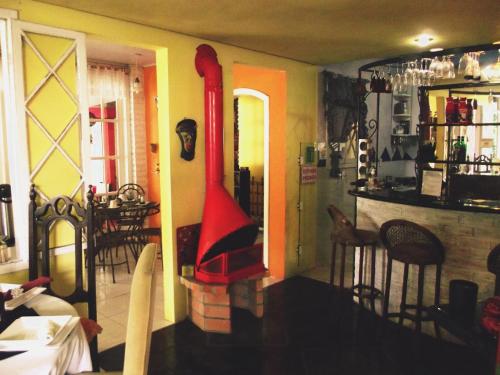 a living room with a fireplace and a red object in a room at Pousada TonaPraia in Florianópolis