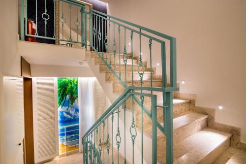 a staircase with green railings in a house at Apartments Master 5 in Herceg-Novi
