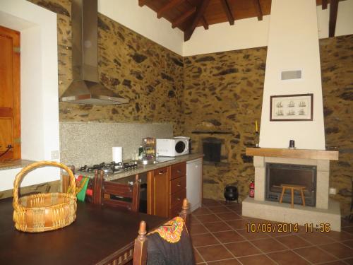 a kitchen with a table and a stove and a fireplace at Casa da Avó, campo praia a 2 kms do mar in Espinho