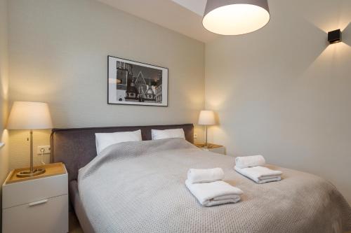 a bedroom with a bed with two towels on it at Riverside Aparthotel Cracow in Kraków
