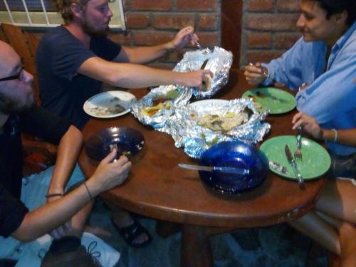 a group of people sitting around a wooden table at Beach cabin ometepe in Altagracia