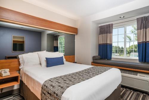 a hotel room with a large bed and a window at Microtel Inn & Suites by Wyndham Springfield in Springfield
