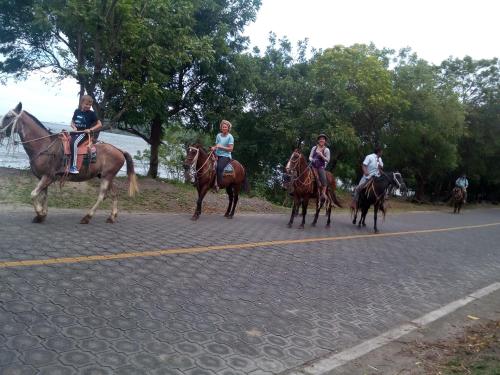 a group of people riding horses down a road at Beach cabin ometepe in Altagracia