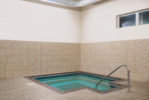 a swimming pool in a room with a tiled wall at Microtel Inn & Suites by Wyndham Springfield in Springfield