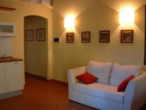 a living room with a white couch with two red pillows at Agriturismo Santa Rosa in Subbiano