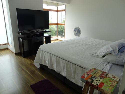 a bedroom with a bed and a flat screen tv at San Borja, bello apartamento in Lima