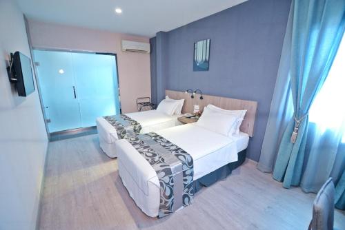 a bedroom with two beds and a sliding glass door at Diamond Inn in Kota Kinabalu