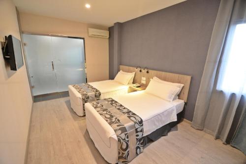a hotel room with two beds and a window at Diamond Inn in Kota Kinabalu