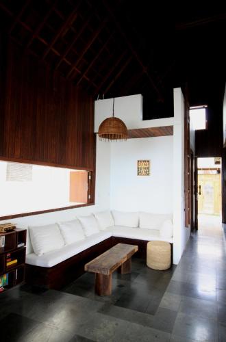 a living room with a white couch and a table at Asmara Villa in Nusa Lembongan