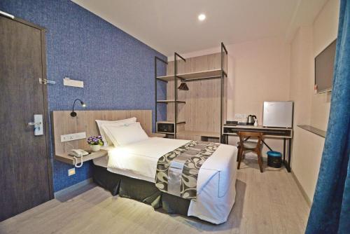 a hotel room with a bed and a desk at Diamond Inn in Kota Kinabalu