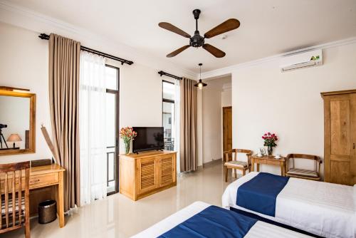 a bedroom with two beds and a ceiling fan at Santa Sea Villa in Hoi An