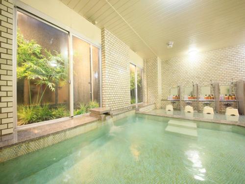 a large swimming pool in a building with a swimming pool at Boso Shirahama Umisato Hotel in Minamiboso
