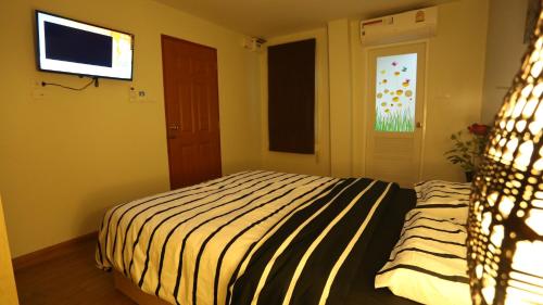a bedroom with a bed and a flat screen tv at TD Bangkok in Bangkok