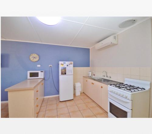 a kitchen with a white refrigerator and a stove at Claire’s Place in Kalbarri