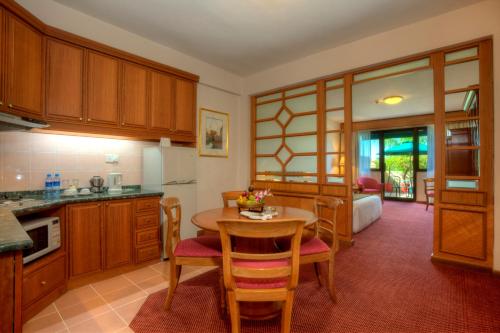 a kitchen with wooden cabinets and a table and chairs at Sunway Hotel Phnom Penh in Phnom Penh