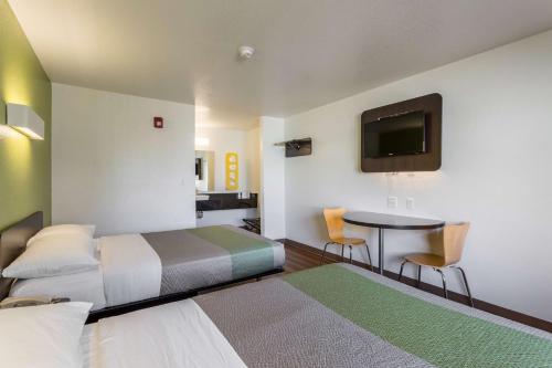 a room with two beds and a table and a tv at Motel 6-El Paso, TX - East in El Paso