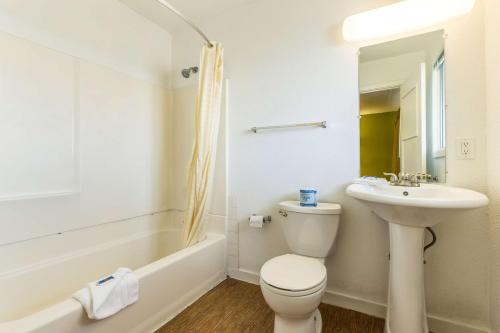 a white bathroom with a toilet and a sink at Motel 6 San Rafael in San Rafael