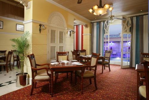 un comedor con mesas y sillas en un restaurante en Chelsea Plaza Hotel, en Dubái