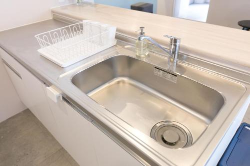 a stainless steel sink in a kitchen counter at hostel DEN in Tokyo