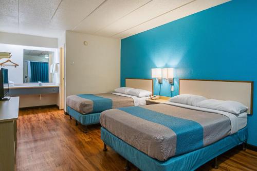 Habitación de hotel con 2 camas y pared azul en Motel 6-Knoxville, TN - North, en Knoxville