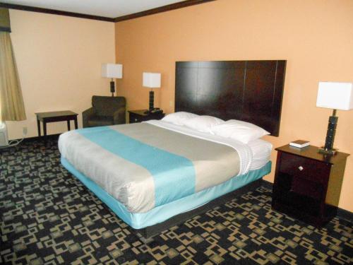 una habitación de hotel con una cama grande y una silla en Motel 6-Joshua, TX, en Joshua