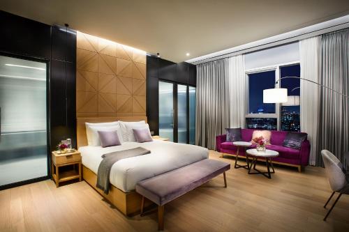 sypialnia z dużym łóżkiem i fioletową kanapą w obiekcie L7 Gangnam w Seulu