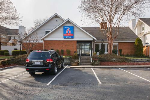 a car parked in a parking lot in front of a store at Studio 6 Extended Stay - Greensboro, NC in Greensboro